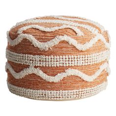 an orange and white basket with fringes on the bottom, sitting on a white surface