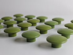 many green knobs on a white surface with no one in the photo looking at them