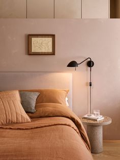 a bedroom with a bed, nightstand and lamp