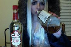 a woman with long white hair drinking from a bottle and wearing a fur hat on top of her head