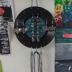 a clock hanging from the side of a wall with chains attached to it's sides