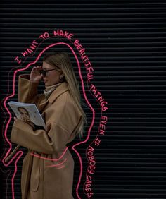 a woman standing in front of a neon sign