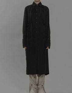 This shirt dress is made of cupro with a beautiful soft texture to the touch. The loose fit is decorated with pleat details at the collar, waist and back and has elegant, elongated cuffs. By buttoning-up the side button at the left side of the waist it can easily transform to a wrap dress style with a slim waistline. Pair it with wide-leg pants to achieve a relaxed chic look.Model’s Measurements: Height: 173cm, Bust: 79cm, Waist: 61cm, Hip: 89cm.Bust: 114cm, Length: 121cmFabric & Care:100% Cupro Relaxed Chic, Wrap Dress Styles, Maxi Shirts, Soft Texture, Wide Leg Pants, Black Shirt, Duster Coat, Wrap Dress, Button Up