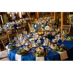 a table is set with blue linens and silverware for an elegant wedding reception