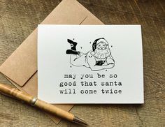 a card with a santa clause saying on it next to a pen and paper clip