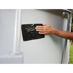 a man is holding onto the side of a water heater with his hand on it