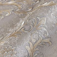 closeup of the gold and silver fabric on an upholstered tablecloth with floral designs