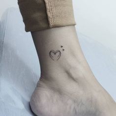 a small heart tattoo on the ankle