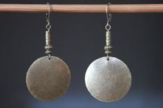 These boho dangle earrings are made with antique brass discs that I hammered first, then to give more texture and character, I domed them. I added some brass spacer beads featuring suns on the top. They hang from antique brass lever backs. Finish : Antiqued Brass disc round hammered and hand domed by myself  1"1/4 ( 32 mm)  Length: 2.5 inches including the antiqued brass lever back For more choices on my brass boho earrings, please refer to the link below : https://www.etsy.com/shop/NtikArtJewel Bohemian Hammered Earrings For Festivals, Hammered Brass Earrings For Festivals, Hammered Brass Earrings For Festival, Rustic Gold Brass Earrings, Hammered Brass Festival Earrings, Bohemian Hammered Metal Earrings, Festival Hammered Brass Earrings, Bohemian Rust Brass Earrings, Bohemian Silver Brass Danglers