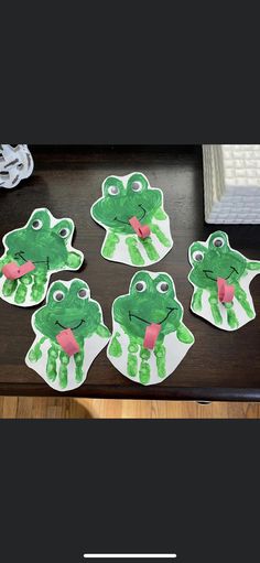 four frog stickers sitting on top of a table