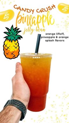 a hand holding up a drink with orange and pineapple on the rim, in front of a white background