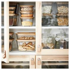 an organized pantry with food items in glass containers and wooden shelves filled with cereals