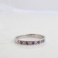 "Beautifully made Simple Half eternity Band Featuring 6 Diamonds and 5 Alexandrite gemstones. Formed as a whole and perfectly round This handmade ring is most Elegant and precious. A real joy to Own, comfortable and Rich in Sparkling presence! Featuring 11 Stones in Total. Six Diamonds (vs) 1.5mm for a Total carat weight of 0.09 Minimum And Five 1.5mm Alexandrite Gemstones (Lab created ones, Real one Are very, Very rare to come by in these small sizes). The Ring weighs approx 3-3.2Grams of Solid White Gold Round Multi-stone Gemstones, Cubic Zirconia Anniversary Gemstone Round Cut, Anniversary Cubic Zirconia Gemstone Round Cut, Diamond Multi-stone Stackable Rings Round Cut, Diamond Multi-stone Stackable Rings, Round Diamond Birthstone Gemstones, Diamond Birthstone Gemstones For Anniversary, Diamond Birthstone Gemstones, Fine Jewelry Round Sapphire Ring With Channel Set