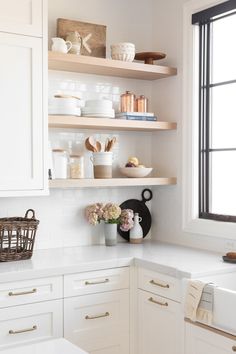 a kitchen with white cabinets and open shelves