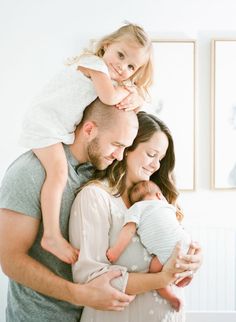 a man and woman holding a baby girl in their arms