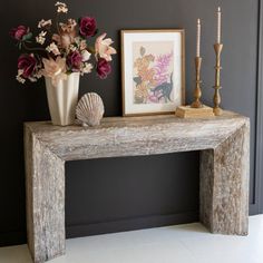 a table with flowers and candles on it next to a framed photograph in a room