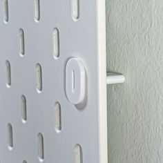 a close up of a white door handle with holes on it