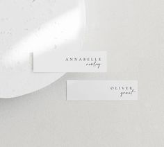 two place cards sitting on top of a white plate