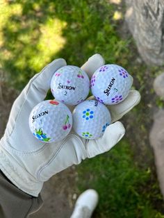 four golf balls are in the palm of someone's hand