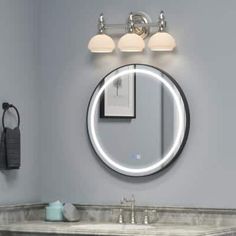 a bathroom with a sink, mirror and lights on the wall above it's counter