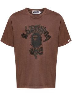 brown cotton crew neck logo print to the front short sleeves logo patch at the sleeve straight hem Brown Short Sleeve T-shirt With Letter Print, Brown Cotton Tops With Logo Print, Brown Logo Print Top For Streetwear, Brown Graphic Print Top For Streetwear, Brown Graphic Print T-shirt, Urban Brown Tops With Graphic Print, Brown Urban Graphic Print Top, Brown Graphic Tee With Logo Print, Brown Short Sleeve T-shirt With Graphic Print