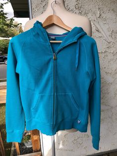 "Teal/ Blue Zip Up Hoodie 85% Cotton 15% Polyester Raglan sleeves Drawstring hood Some minor piling Size Large Measurements taken while laying flat Neck 8\" Pit to Pit 20\" Sleeves from pit to edge 22\" Length from shoulder to bottom 22\" Purchase price includes free shipping in Canada and the USA International shipping is available, please contact before purchase for shipping quote Any questions, just ask ! Vintage item, regular wear due to age should be expected Any known flaws/ markings will be listed No returns/ exchanges, but please contact if there is an issue with your item" Blue Fall Sweats With Drawstring Hood, Blue Sweats With Drawstring Hood For Fall, Blue Hooded Sweats With Drawstring Hood, Blue Hoodie With Drawstring For Winter, Winter Blue Sweats With Drawstring Hood, Blue Drawstring Hoodie For Winter, Blue Hooded Jacket With Drawstring And Long Sleeves, Blue Long Sleeve Hooded Jacket With Drawstring, Blue Sweats With Drawstring Hood