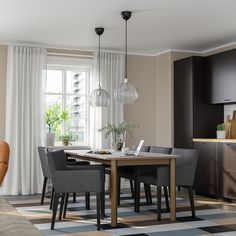 a dining room table surrounded by chairs in front of a window