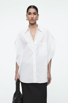 This season, the womenswear team embrace a fresh perspective on the classic cotton shirt. This white version is defined by a circle-cut silhouette that softens the lines of traditional tailoring – note the curved shoulders and three-quarter-length sleeves. Relaxed fitButton closure Shell: 100% Cotton. Excluding trims / Machine wash Back length of size EU 36 is 76.1cm / Model wears a size EU 36 Formal Half Sleeve Tops For Summer, Elegant Half Sleeve Relaxed Fit Blouse, Half Sleeve Shirt For Office In Spring, Spring Office Shirt With Half Sleeves, Spring Office Half Sleeve Shirt, Elegant Half Sleeve Relaxed Fit Top, Elegant Half Sleeve Summer Shirt, Modern Shirt With Rolled Sleeves For Work, Modern Shirt For Workwear With Rolled Sleeves