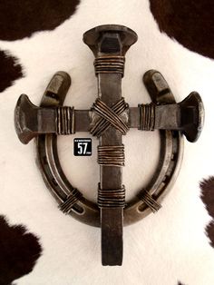 a cross made out of metal on top of a cowhide rug