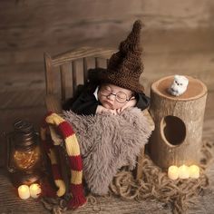 a baby dressed as harry potter is sleeping in a chair