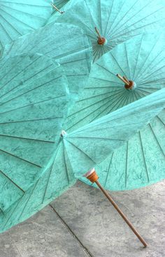 several open umbrellas sitting on the ground in front of some concrete flooring,