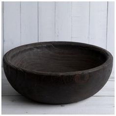 a wooden bowl sitting on top of a white table