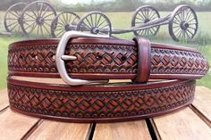 a brown belt is sitting on top of a wooden table with wheels in the background