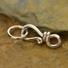 a pair of silver rings sitting on top of a rock