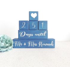 a wooden block set with the date and wedding date on it, next to a flower