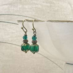 Small but stunning! Beautiful emerald green color cathedral bead earrings. Small, dainty, petite earrings. Lightweight and easy to wear all day. Handmade with an 8mm Czech glass cathedral bead. This bead is a beautiful emerald green color with a bronze finish on the top and bottom of the bead.  Paired with bronze accent beads and a small fire-polished matching green crystal, top it off. These earrings are perfect for those who prefer small dangle earrings. Earrings are a total of one inch in len Green Beaded Crystal Earrings, Nickel-free Green Drop Earrings, Green Nickel-free Drop Earrings, Elegant Green Dangle Beaded Earrings, Hypoallergenic Green Round Bead Earrings, Hypoallergenic Green Earrings For May Birthstone, Green Adjustable Dangle Crystal Earrings, Adjustable Nickel Free Green Crystal Earrings, Adjustable Green Crystal Dangle Earrings