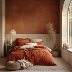 a bed with an orange comforter and pillows