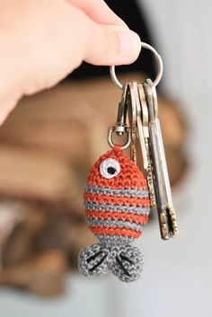 a hand holding a crocheted keychain with an eyeball on it