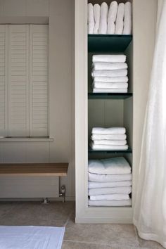 a shelf filled with lots of white towels