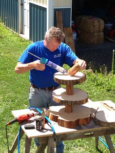 a man in blue shirt sanding wood on top of a table