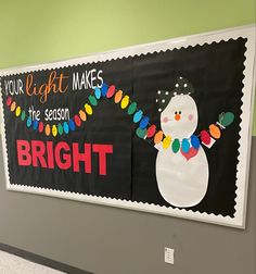 a bulletin board that has been decorated with christmas lights and a snowman on it