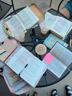 several open books are sitting on a table with other items around it and someone's feet in the background