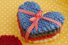 a knitted heart sitting on top of a red and white polka dot table cloth