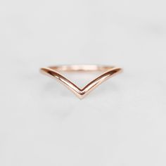 a rose gold chevron ring on a white background