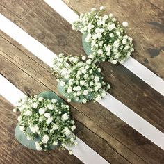 three bouquets of baby's breath sit on top of each other in white ribbons