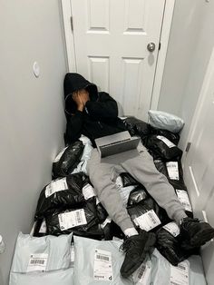 a man is laying on the floor surrounded by bags