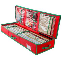 an open red suitcase filled with lots of wrapping paper and other items on top of it