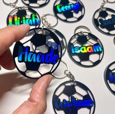 a hand holding a soccer ball shaped keychain with the word handle on it