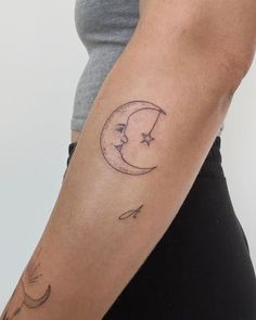 a woman's arm with a crescent and stars tattoo on it