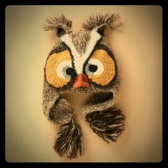 a knitted owl hat hanging on a wall